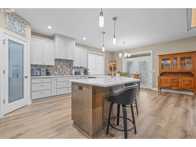 a kitchen with a table chairs refrigerator and cabinets