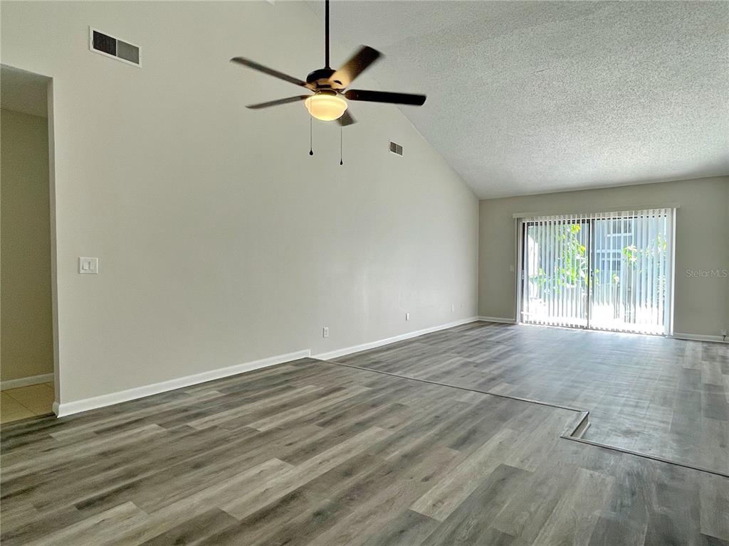 702 St Matthew Circle Altamonte Springs, FL 32714 - Photo 4 of 27 an empty room with wooden floor fan and windows