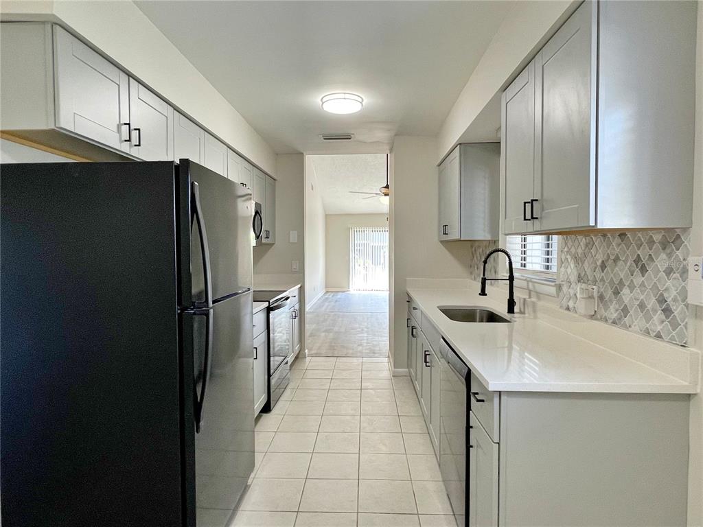 702 St Matthew Circle Altamonte Springs, FL 32714 - Photo 6 of 27 a kitchen with stainless steel appliances a refrigerator sink and cabinets