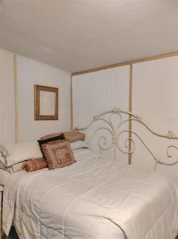 a bedroom with a bed and a painting on the wall