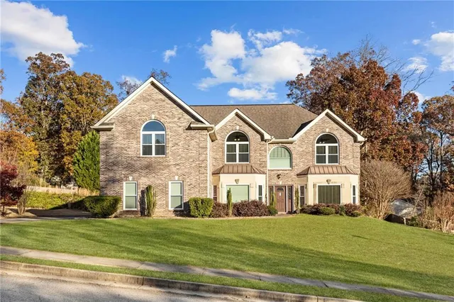 a view of a white house with a yard and plants