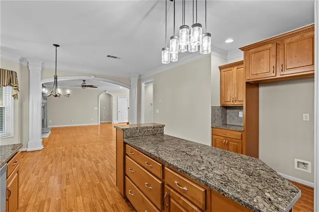 a spacious bathroom with a granite countertop sink and a wooden floor