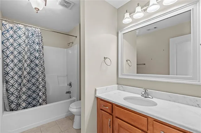 an empty room with windows and a chandelier fan