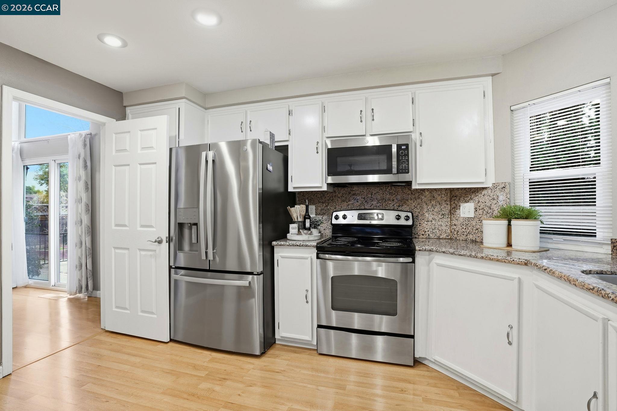 5454 Anselmo Court Concord, CA 94521 - Photo 13 of 44 a kitchen with granite countertop a refrigerator stove and microwave
