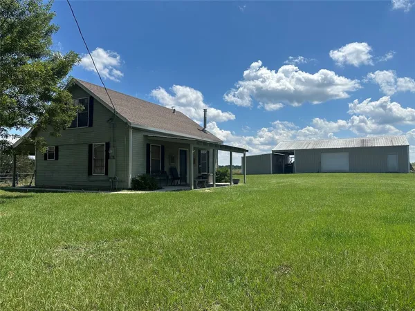a view of a house with a big yard and a large tree