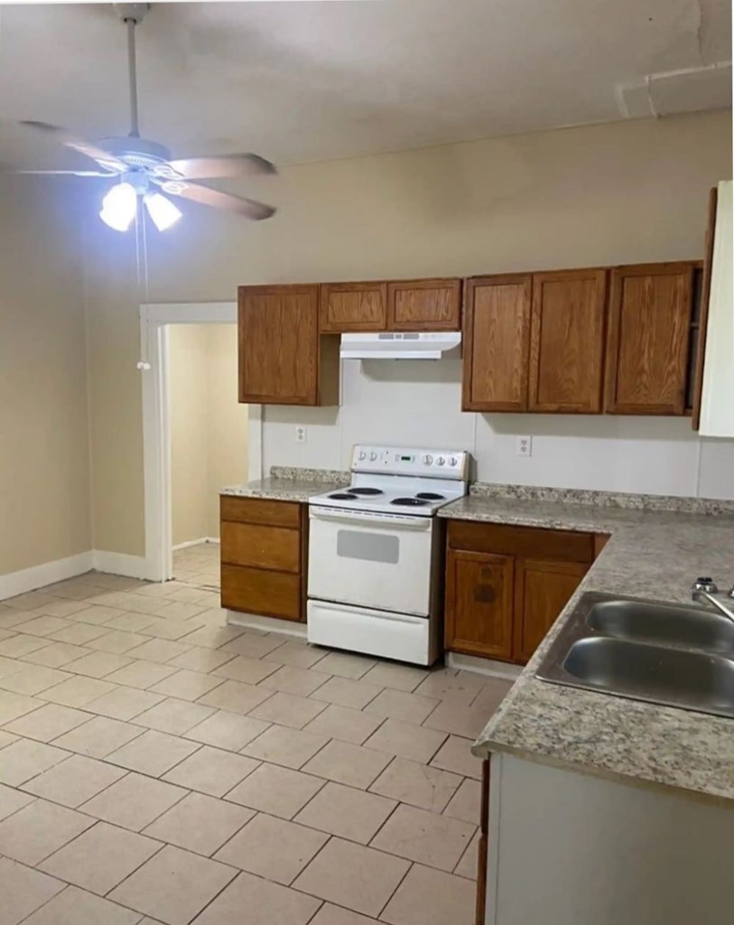 2917 13th Avenue Columbus, GA 31904 - Photo 5 of 6 a kitchen with granite countertop a sink cabinets and stainless steel appliances