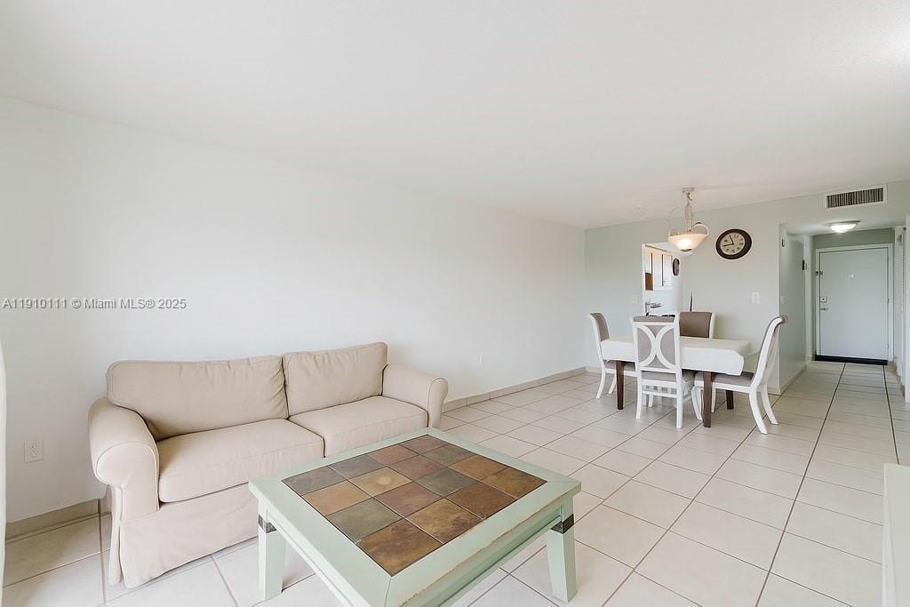 3110 North Pine Island Road, Unit 409 Sunrise, FL 33351 - Photo 11 of 18 a living room with furniture a dining table and a rug