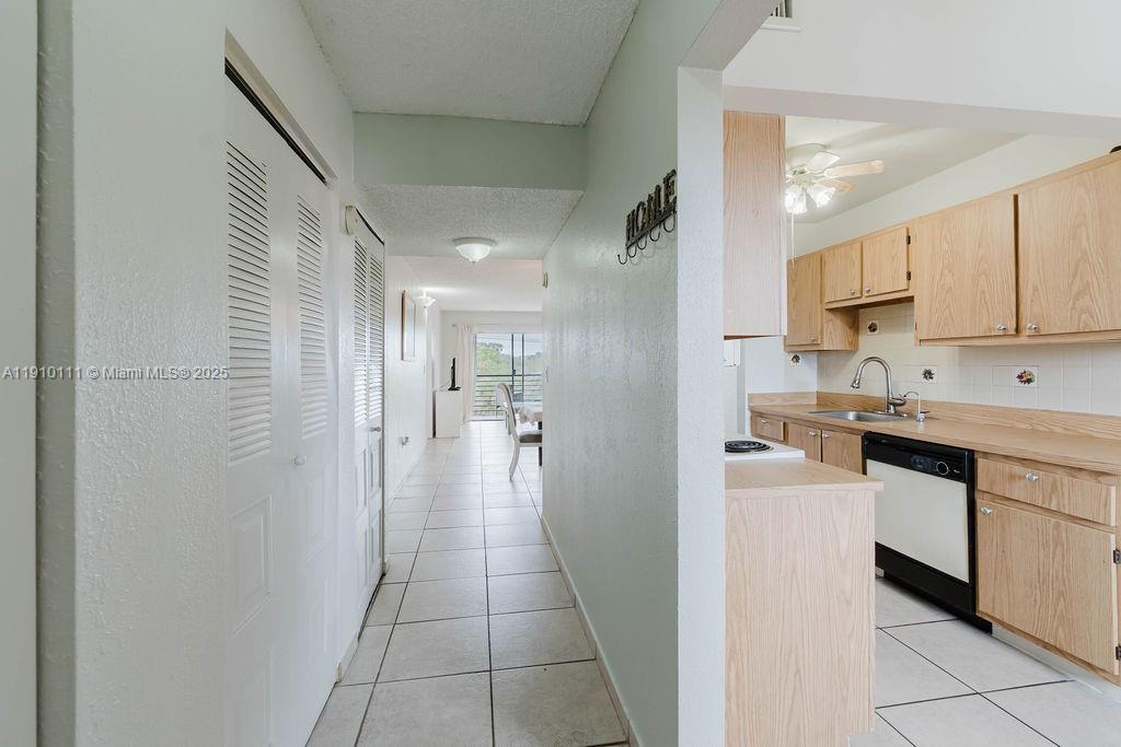3110 North Pine Island Road, Unit 409 Sunrise, FL 33351 - Photo 13 of 18 a open kitchen with white cabinets and stainless steel appliances