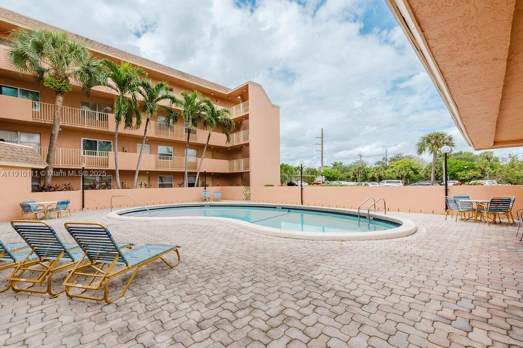 3110 North Pine Island Road, Unit 409 Sunrise, FL 33351 - Photo 14 of 18 a view of a swimming pool with a lounge chairs