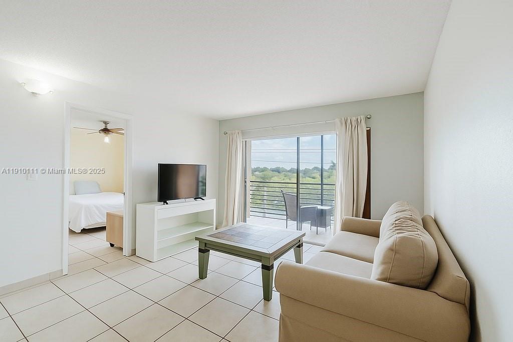 3110 North Pine Island Road, Unit 409 Sunrise, FL 33351 - Photo 2 of 18 a living room with furniture and a flat screen tv