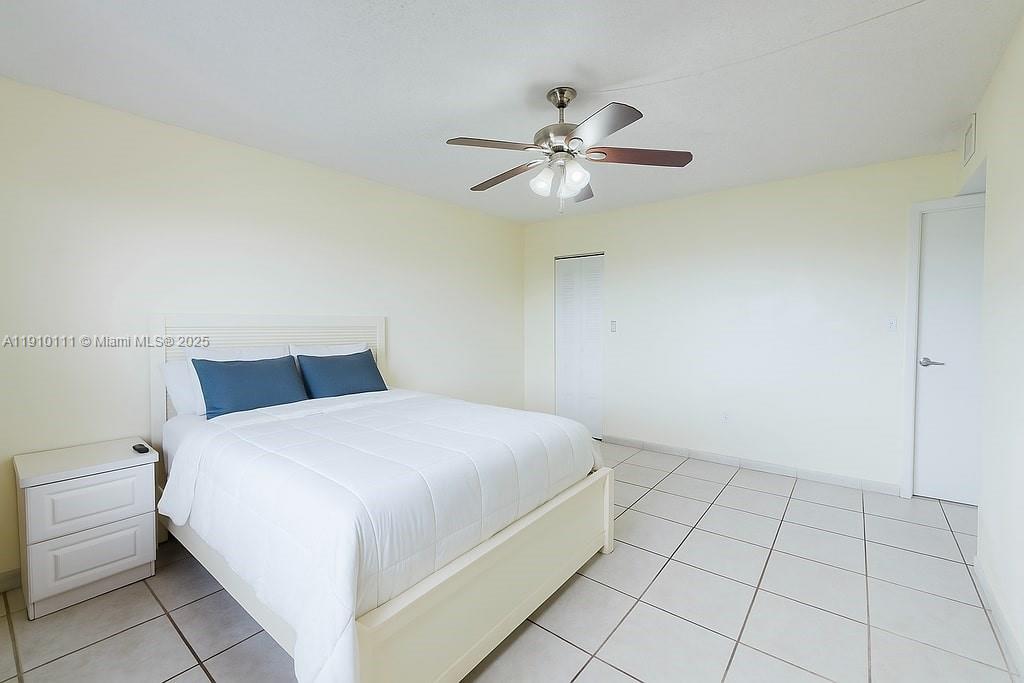 3110 North Pine Island Road, Unit 409 Sunrise, FL 33351 - Photo 6 of 18 a bedroom with a bed and a ceiling fan