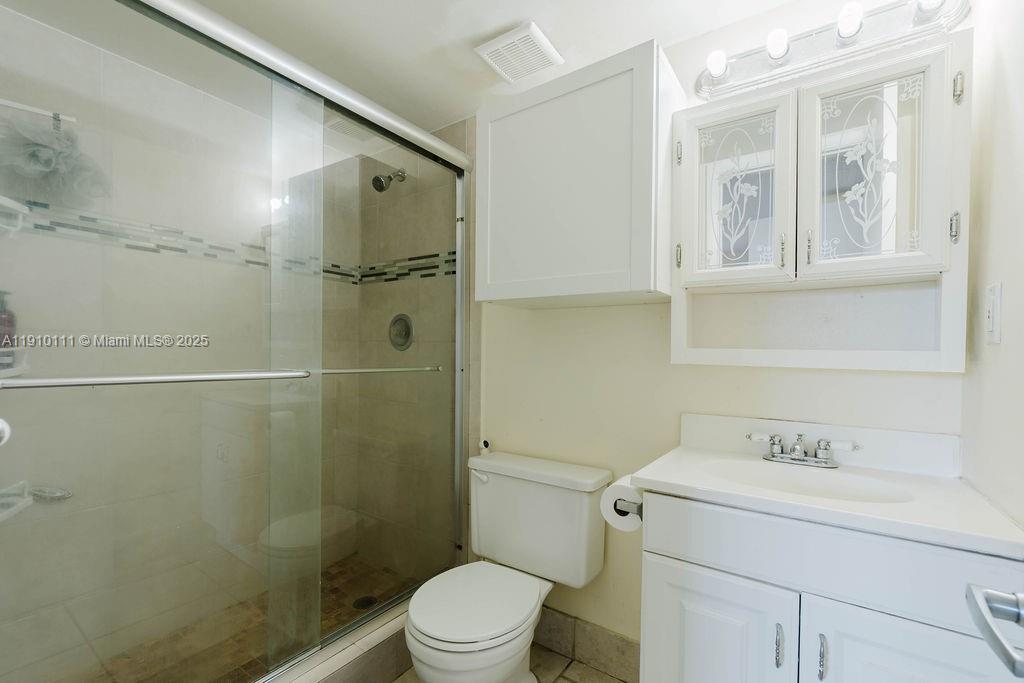 3110 North Pine Island Road, Unit 409 Sunrise, FL 33351 - Photo 7 of 18 a bathroom with a shower sink vanity mirror and toilet
