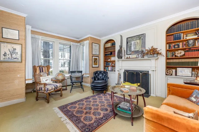 a living room with furniture fireplace and a large window