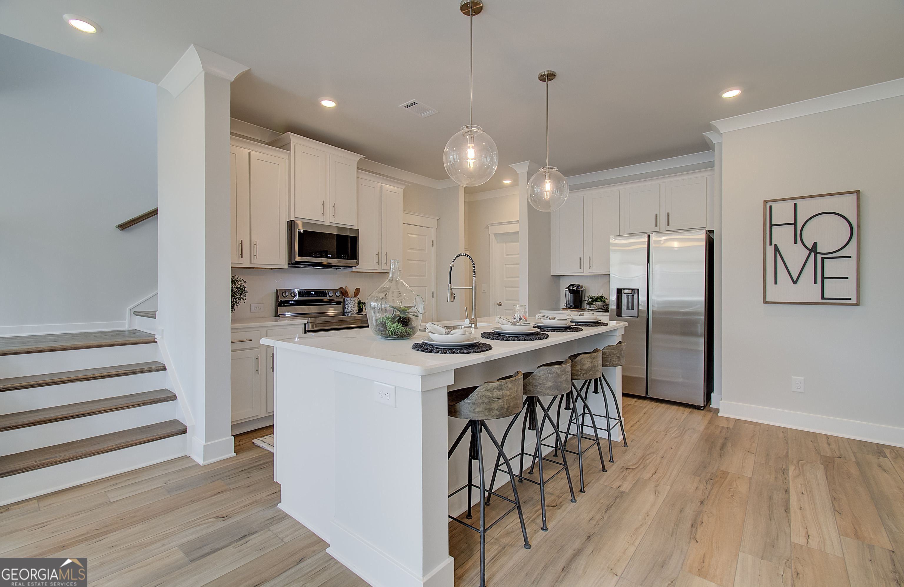 182 Depot Landing Road, Unit 65A Auburn, GA 30011 - Photo 11 of 37 a kitchen with stainless steel appliances kitchen island granite countertop a refrigerator a stove a microwave oven a sink with island and chairs