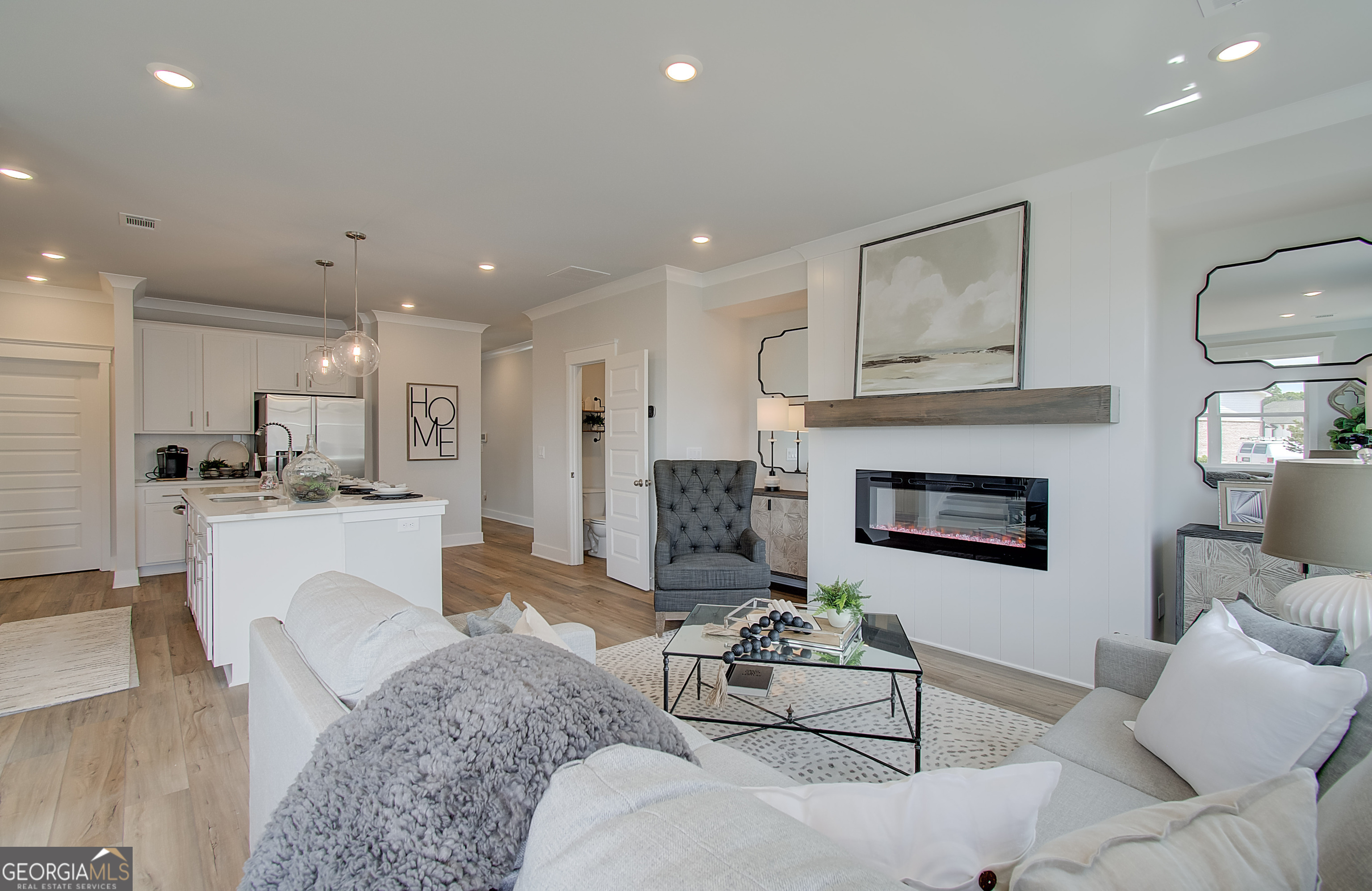 182 Depot Landing Road, Unit 65A Auburn, GA 30011 - Photo 7 of 37 a living room with furniture a fireplace and kitchen view