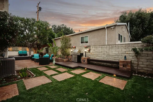 a view of a house with backyard and sitting area