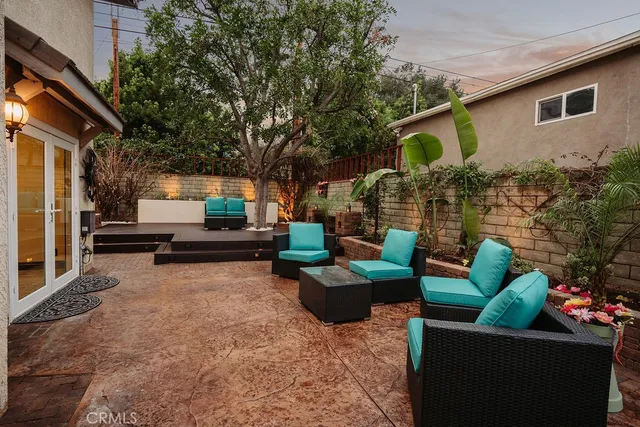 a view of a patio with couches table and chairs and potted plants