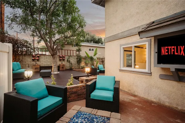 a backyard of a house with wooden floor and outdoor seating