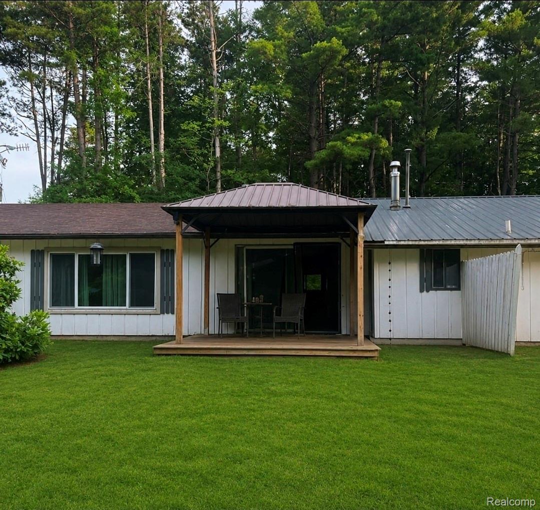 9704 Slattery Road Clifford, MI 48727 - Photo 1 of 1 Expansive green lawn with a covered wooden deck