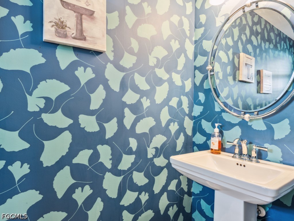 232 La Peninsula Boulevard, Unit 232 Naples, FL 34113 - Photo 22 of 44 a bathroom with a sink and a mirror
