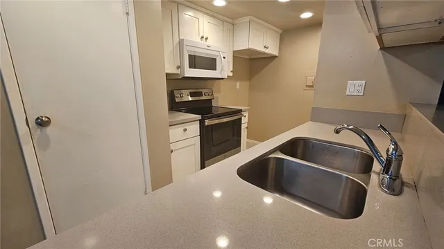 a kitchen with a refrigerator sink and cabinets