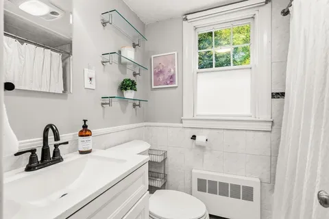 a bathroom with a sink a toilet and a window