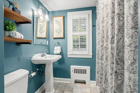 a bathroom with a sink a toilet and a window