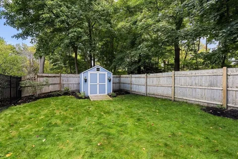 a view of a backyard with a small cabin and wooden fence