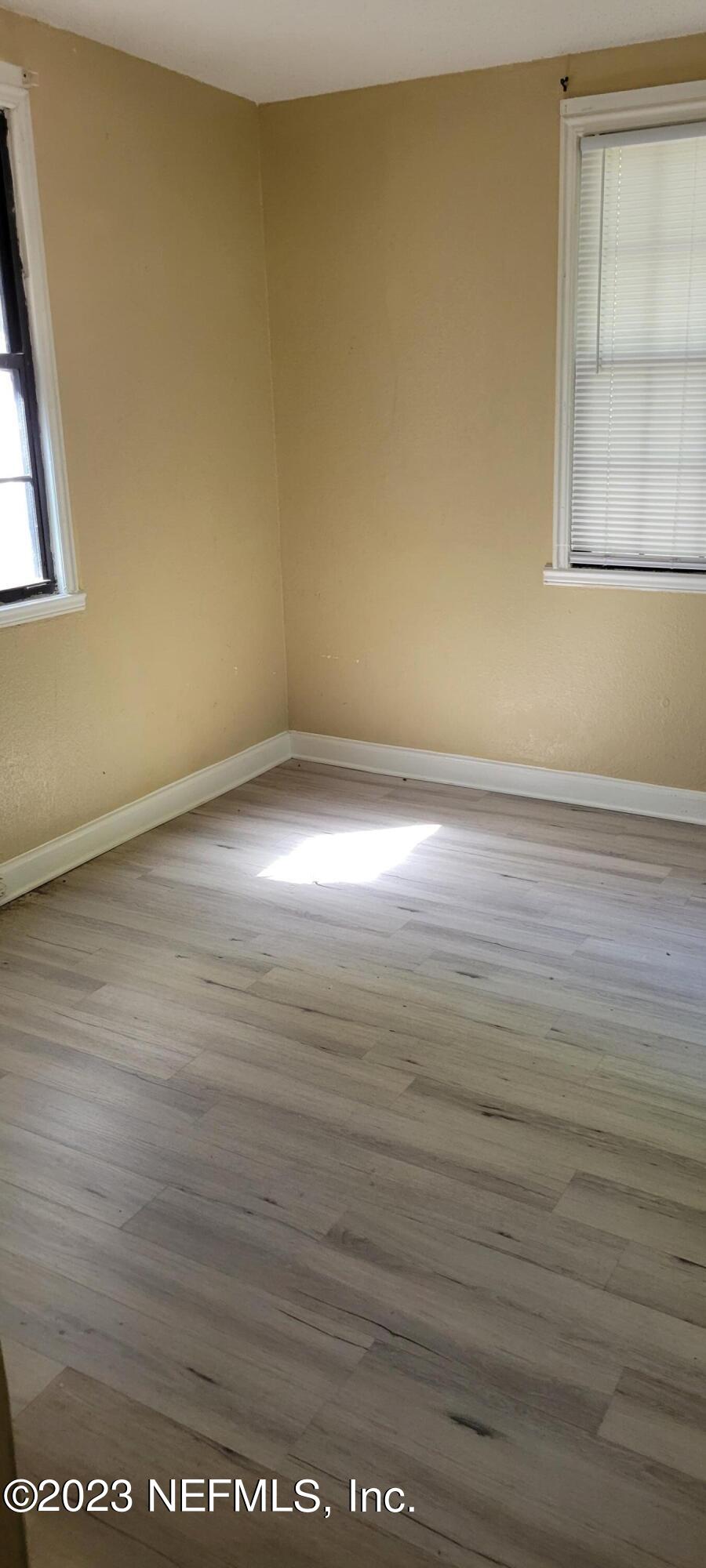 4069 Walnut Street Jacksonville, FL 32206 - Photo 12 of 14 an empty room with wooden floor and windows