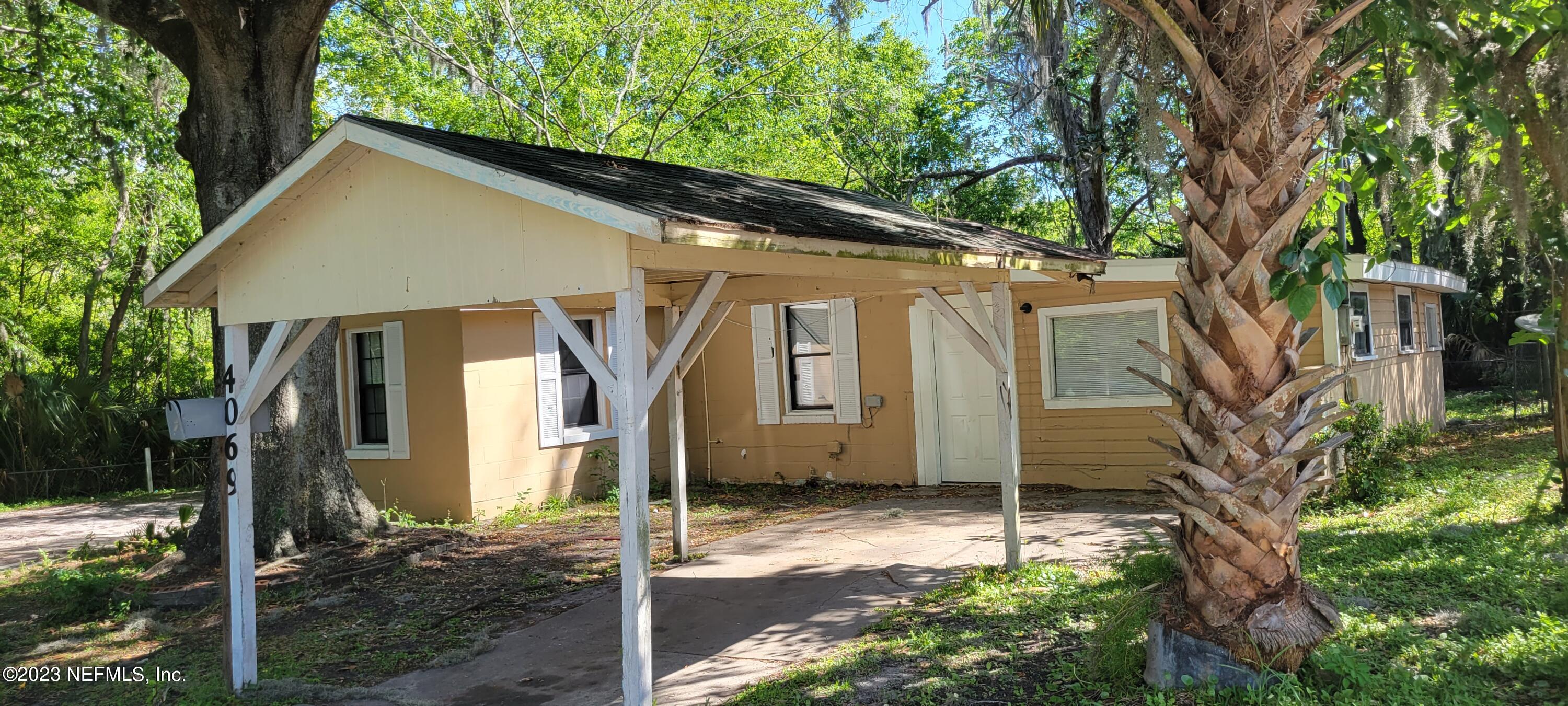 4069 Walnut Street Jacksonville, FL 32206 - Photo 2 of 14 a view of a house with a small yard plants and large tree