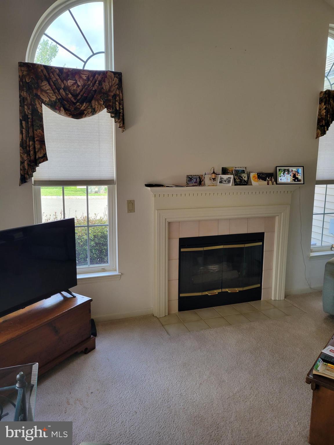 43 Woolsey Court Pennington, NJ 08534 - Photo 4 of 5 a living room with a fireplace and a flat screen tv