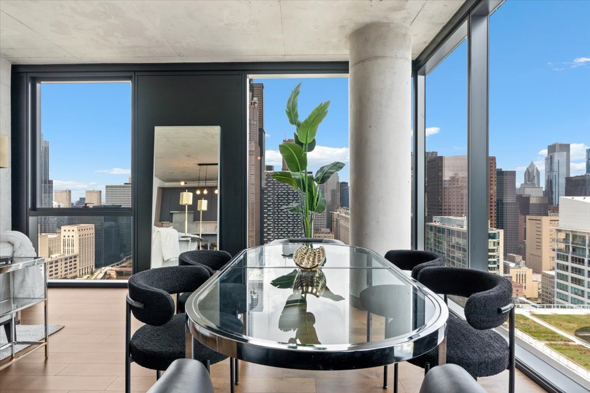 234 West Polk Street, Unit 3708 Chicago, IL 60607 - Photo 12 of 44 a view of a dining room with furniture large windows and wooden floor