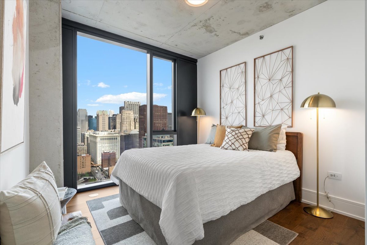 234 West Polk Street, Unit 3708 Chicago, IL 60607 - Photo 20 of 44 a bedroom with a large bed and a chandelier