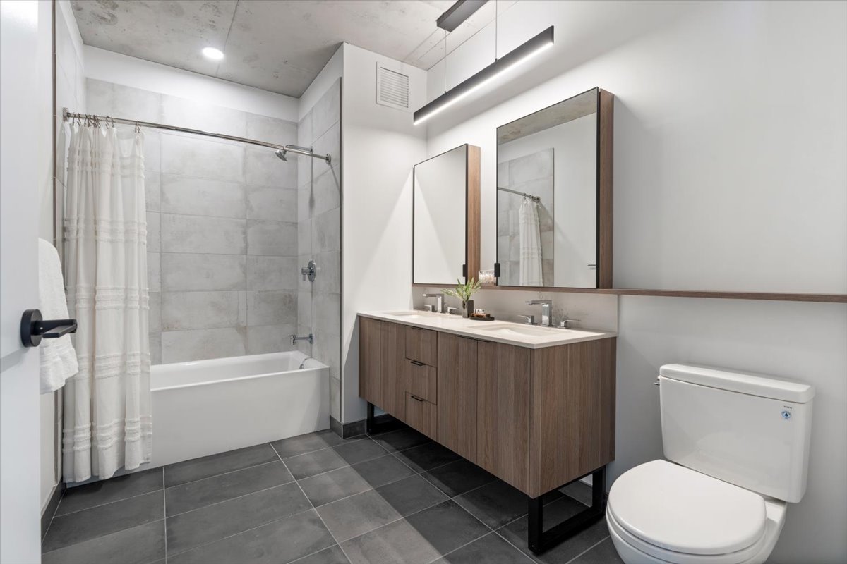 234 West Polk Street, Unit 3708 Chicago, IL 60607 - Photo 21 of 44 a bathroom with a bathtub shower sink mirror and toilet