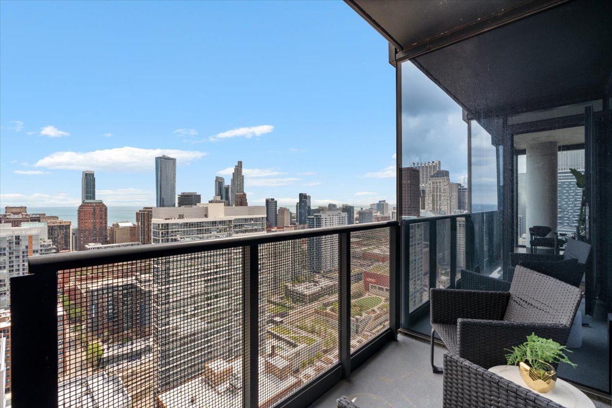 234 West Polk Street, Unit 3708 Chicago, IL 60607 - Photo 22 of 44 a view of a balcony with furniture and wooden floor