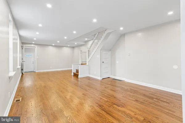a view of an empty room with wooden floor