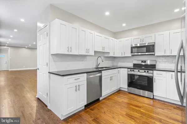 a kitchen with granite countertop a stove top oven and cabinets