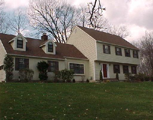 4 Tall Oaks Road Wilton, CT 06897 - Photo 1 of 1 a front view of a house with a garden and plants
