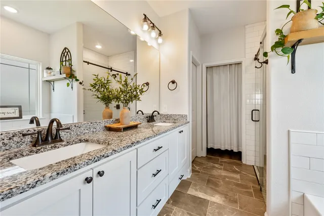 a bathroom with a granite countertop sink a mirror and a shower