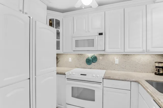 a kitchen with white cabinets and white appliances