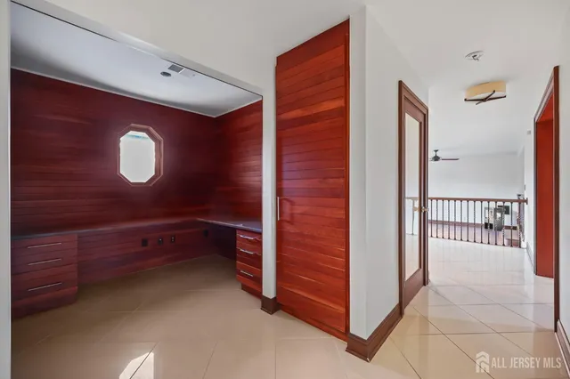 a view of empty room with wooden floor and ceiling fan