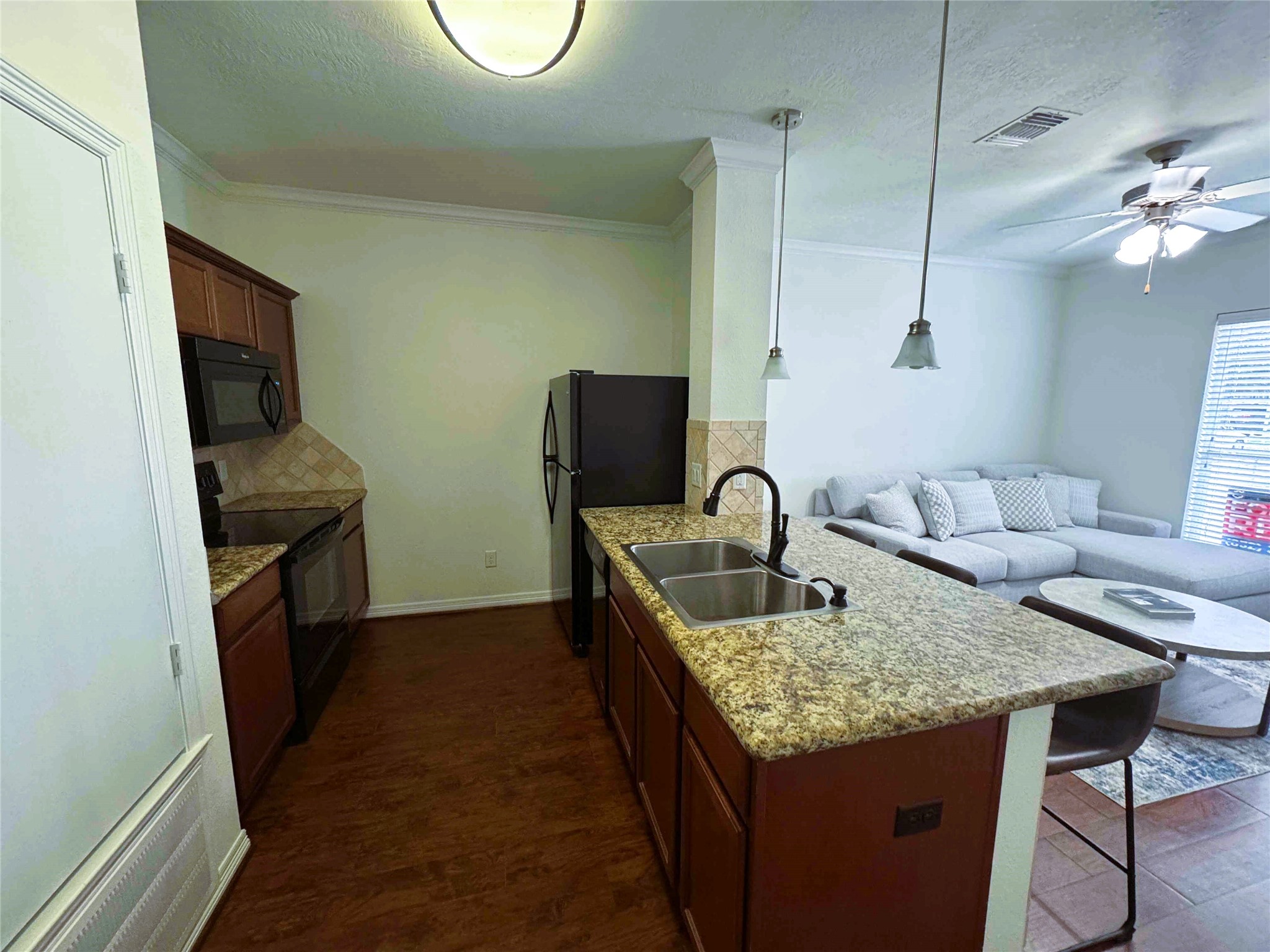 1198 Jones-Butler Road, Unit 2707 College Station, TX 77840 - Photo 7 of 24 a kitchen with kitchen island granite countertop a sink a counter top space and cabinets