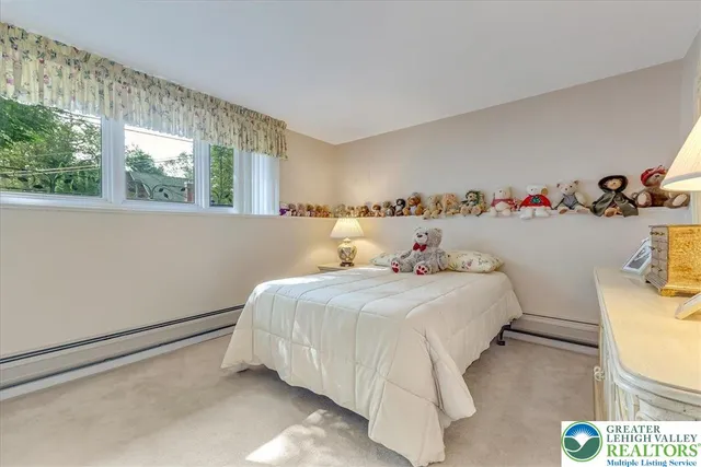 a bedroom with a bed and a dresser next to a window