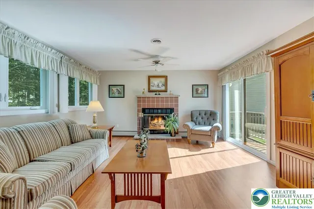 a living room with furniture fireplace and a large window