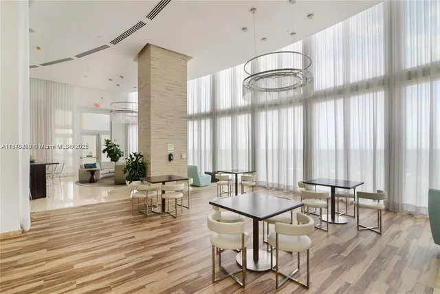 a view of a a dining room with furniture window and wooden floor