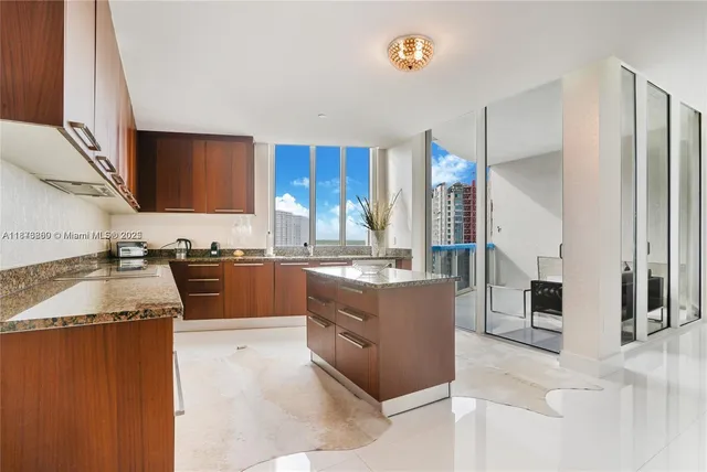 a large kitchen with granite countertop a sink counter top space and cabinets