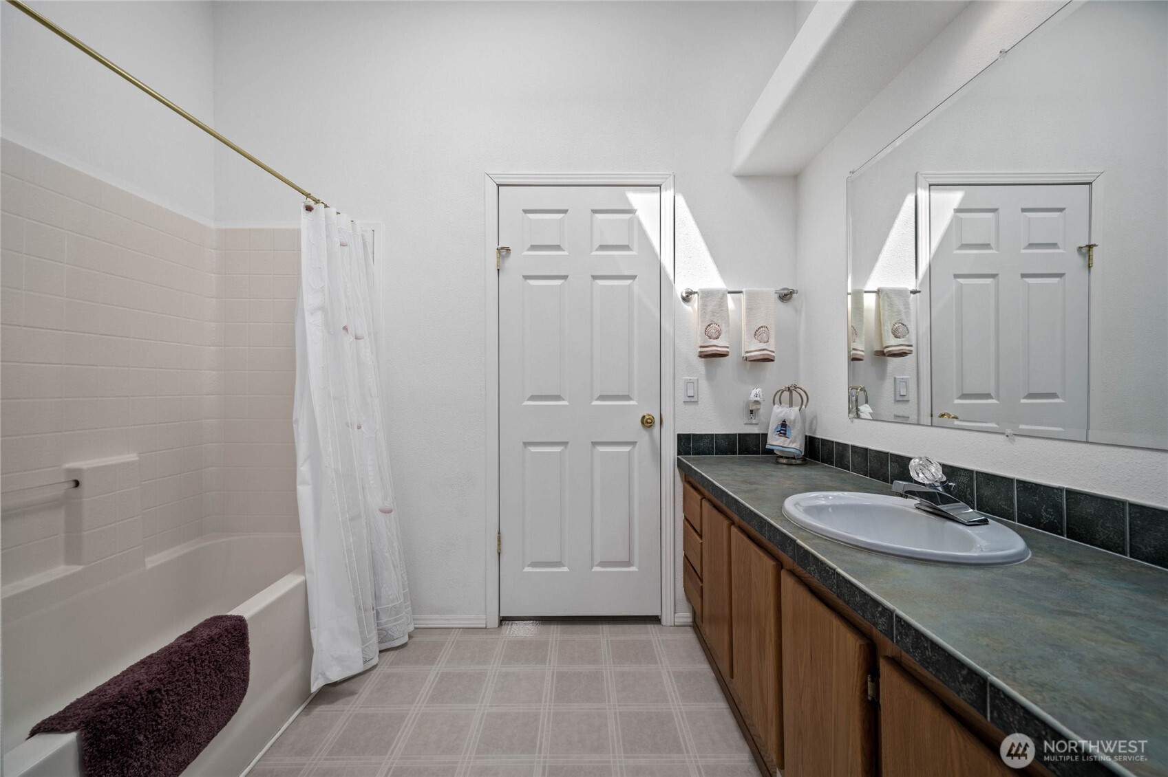 155 Airport Perimeter Way Decatur Island, WA 98221 - Photo 16 of 26 a bathroom with a double vanity sink a mirror and a bathtub