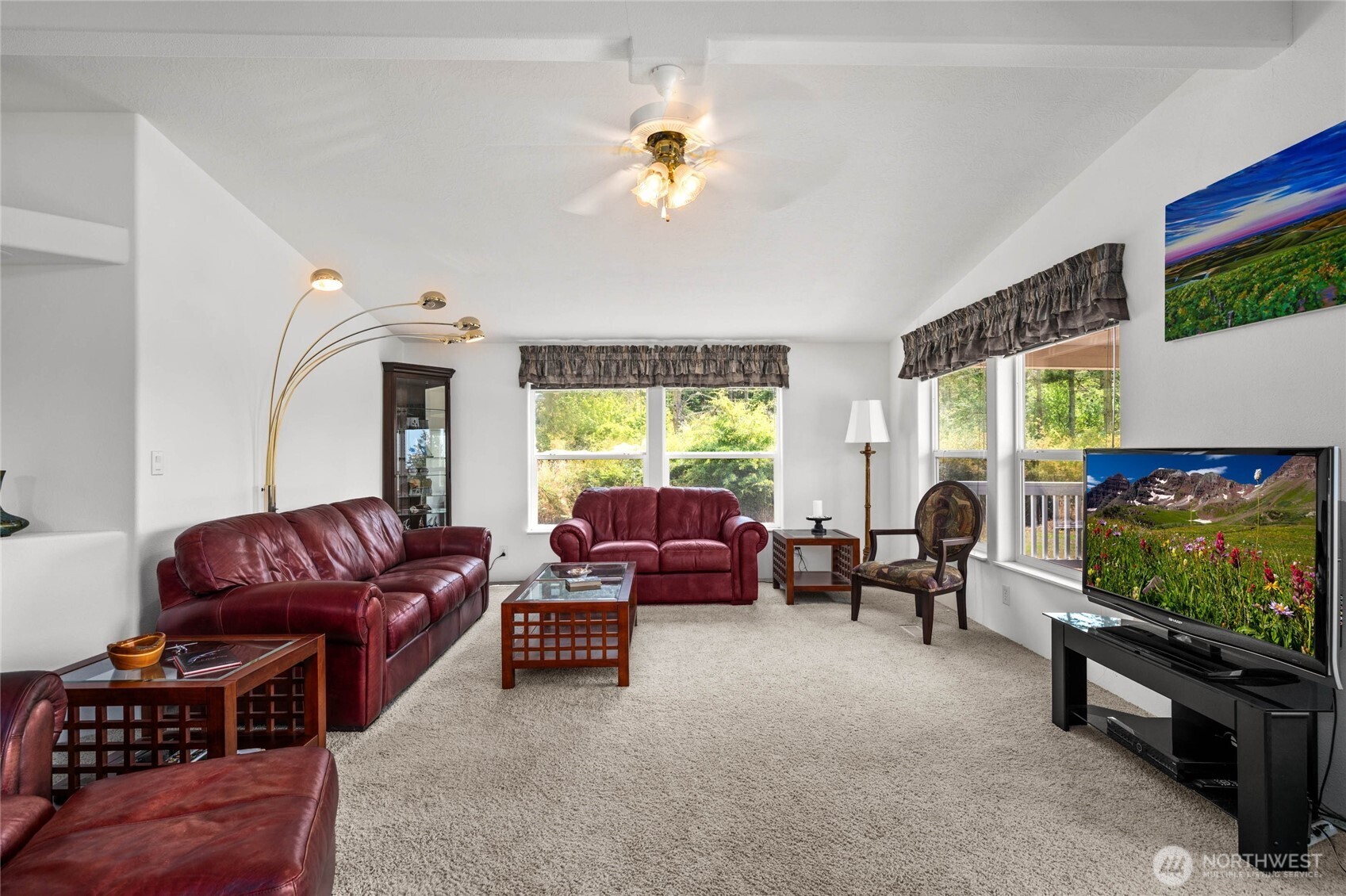 155 Airport Perimeter Way Decatur Island, WA 98221 - Photo 6 of 26 a living room with furniture a flat screen tv and floor to ceiling window