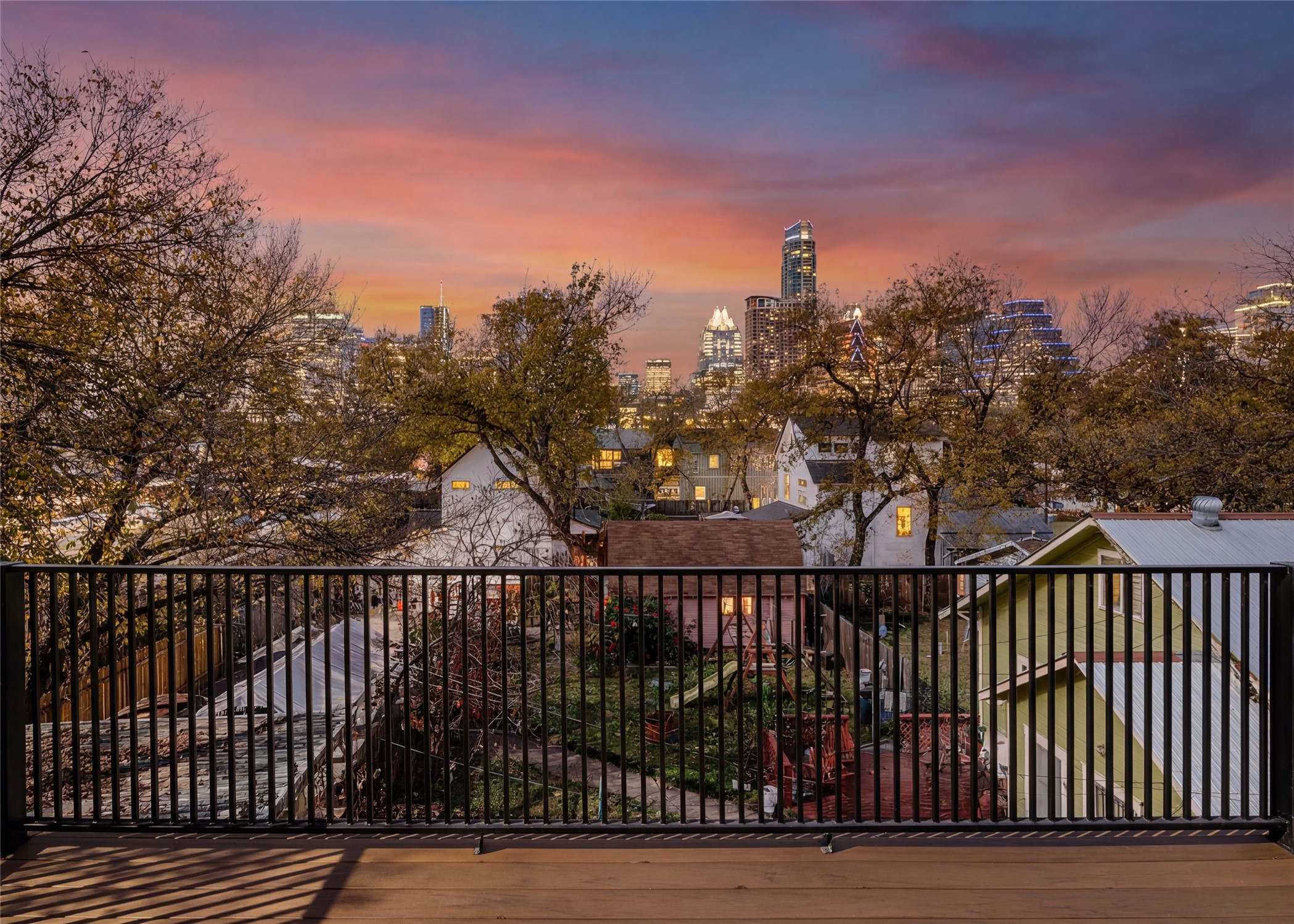106 Comal Street Austin, TX 78702 - Photo 10 of 40 A vibrant sunset paints the skyline, creating a breathtaking backdrop to the cityscape from this elevated deck.