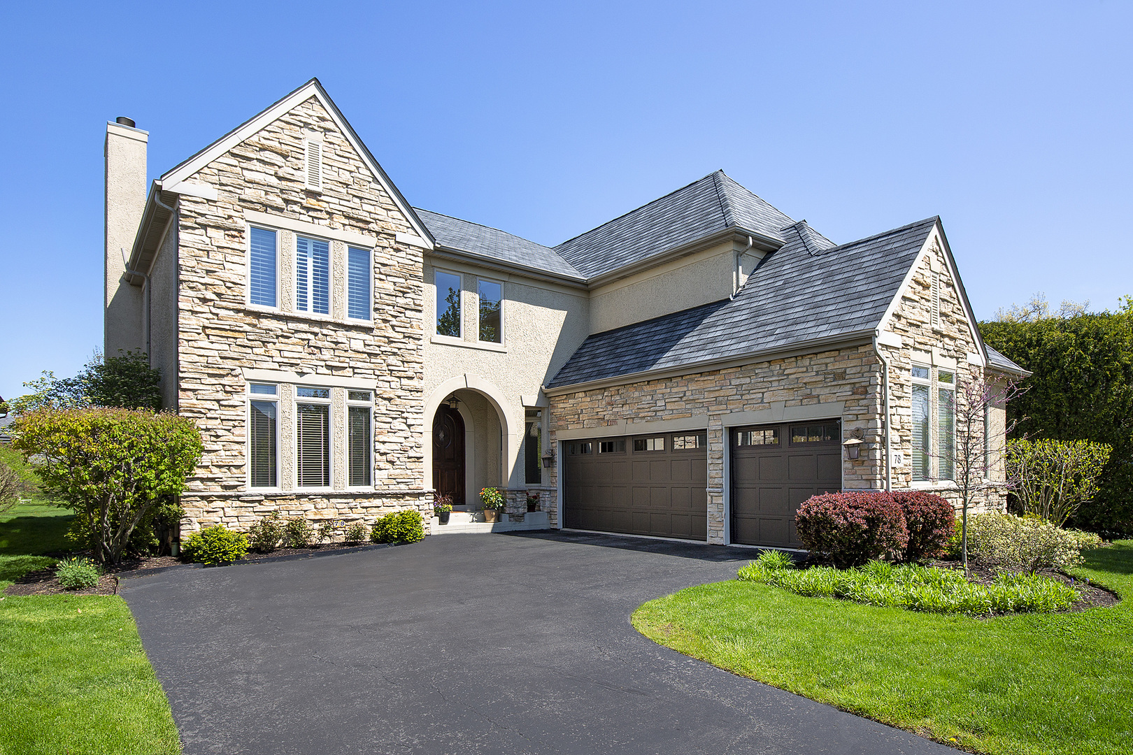 a front view of a house with a garden and plants